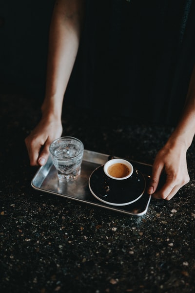 人拿着托盘饮用玻璃杯和咖啡杯
